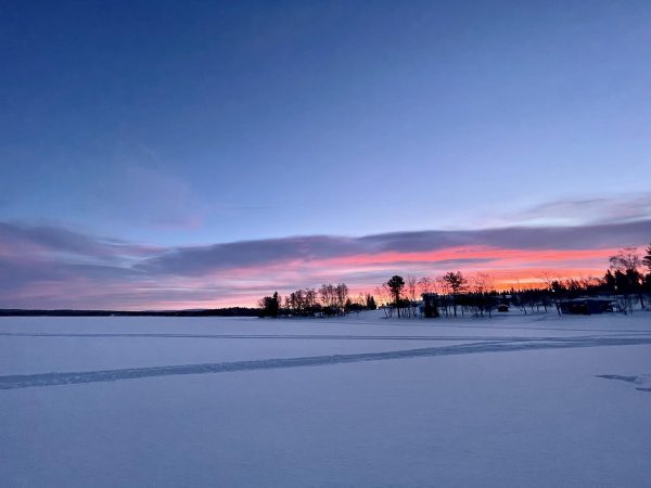 Zonsopkomst bij een besneeuwd meer in Lapland